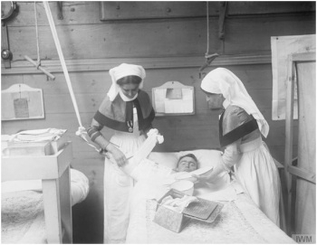 Nurses bandaging an arm case in a Red Cross barge on the River Lys near Aire, 14 February 1918. Image Courtesy of Imperial War Museum